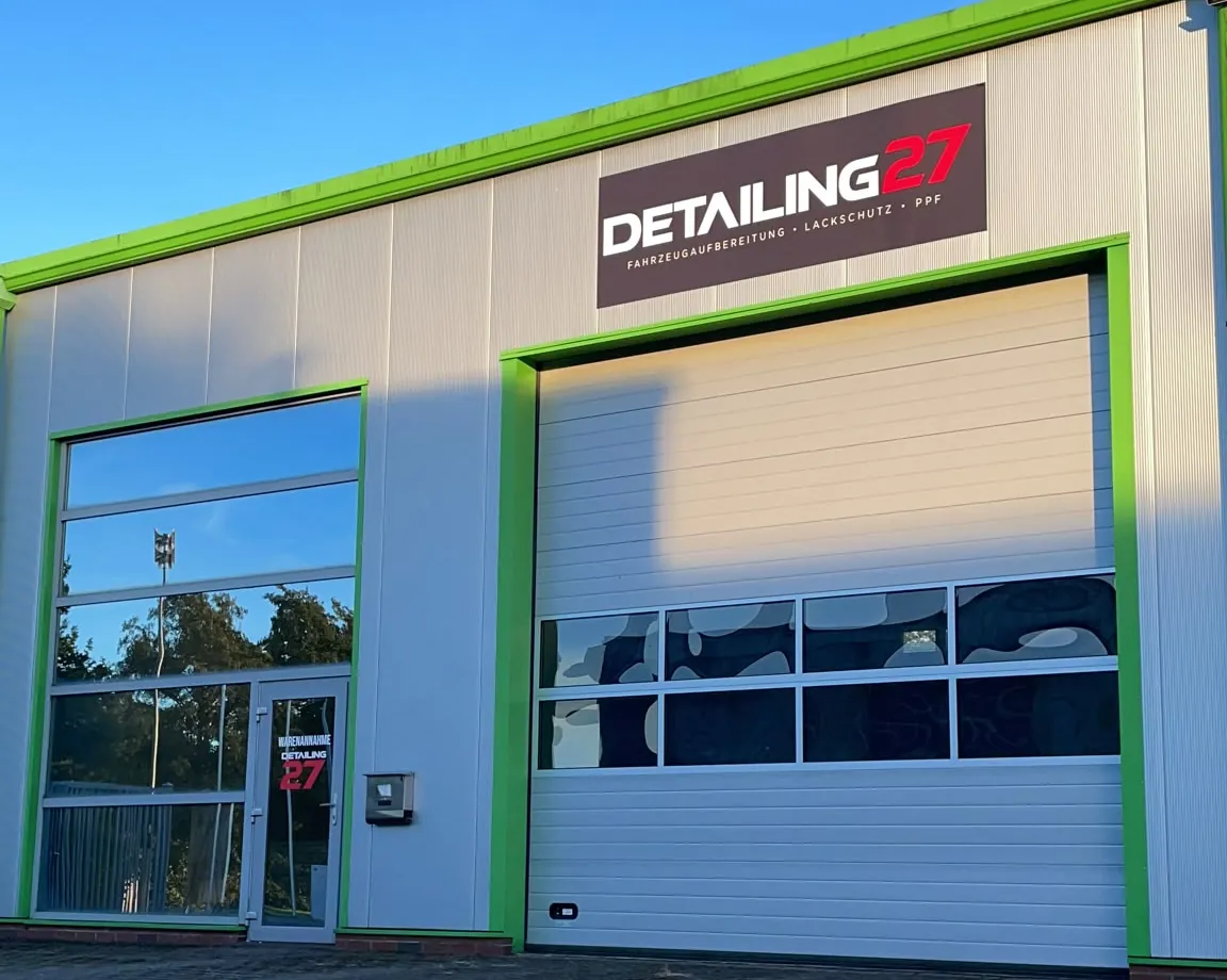 Eingang der Detailing27 Halle in Hude mit Logo über dem Rolltor
