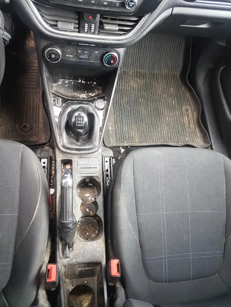 Innenraum eines Ford Fiesta mit Mittelkonsole und Fußraum – vorher
