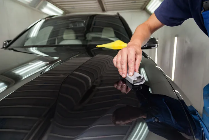 Keramikversiegelung wird mit einem Applikator auf die Motorhaube aufgetragen